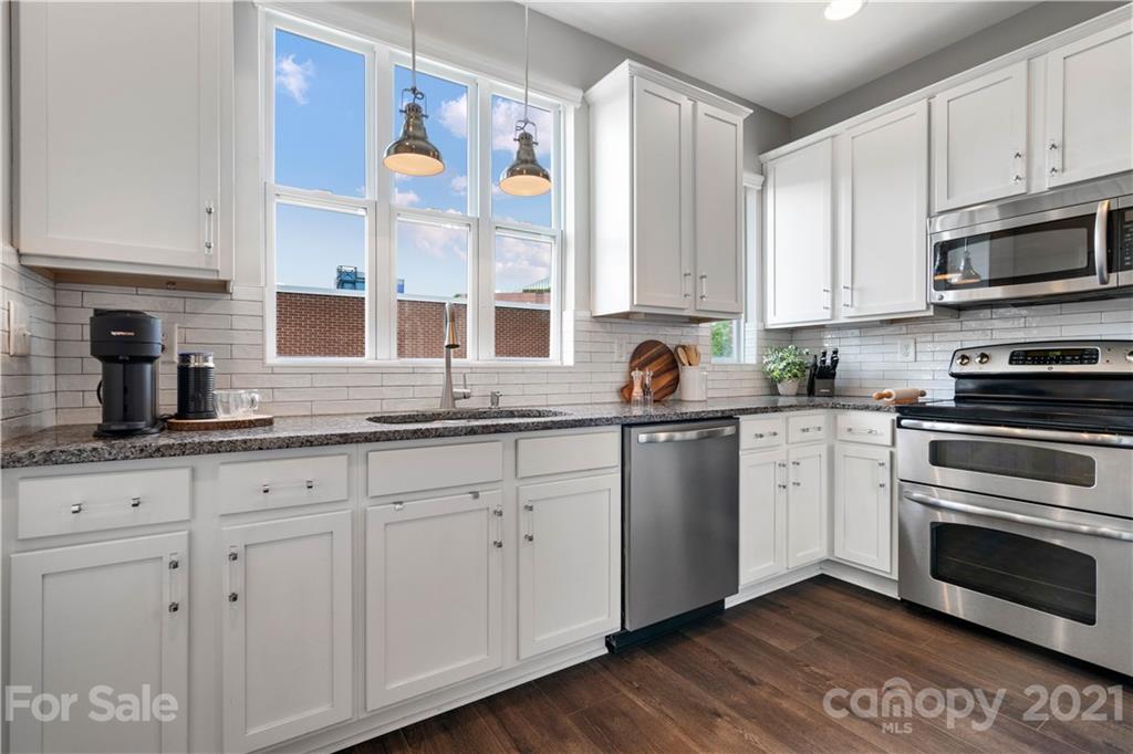1433 Camden Road Charlotte, NC 28203 - Photo 6 of 22 a kitchen with granite countertop white cabinets stainless steel appliances a sink and a window