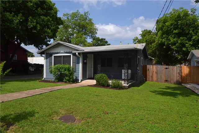 a view of a house with a yard and tree s