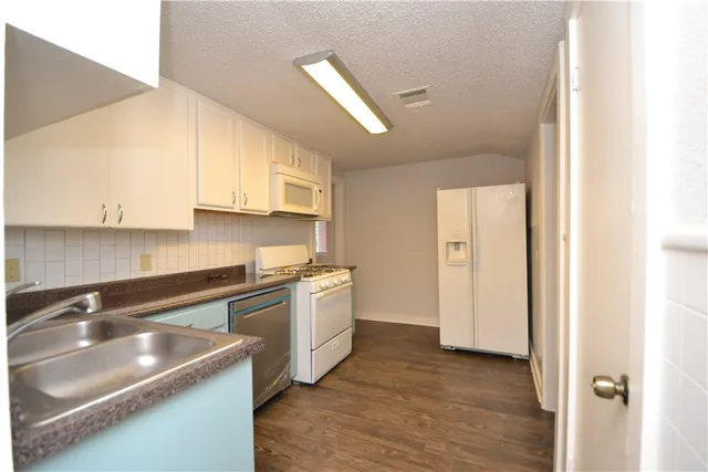 a kitchen with stainless steel appliances granite countertop a sink and a stove