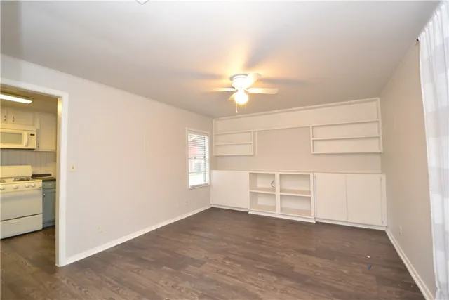 an empty room with cabinet and windows