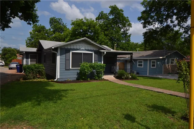 a front view of a house with a yard and trees