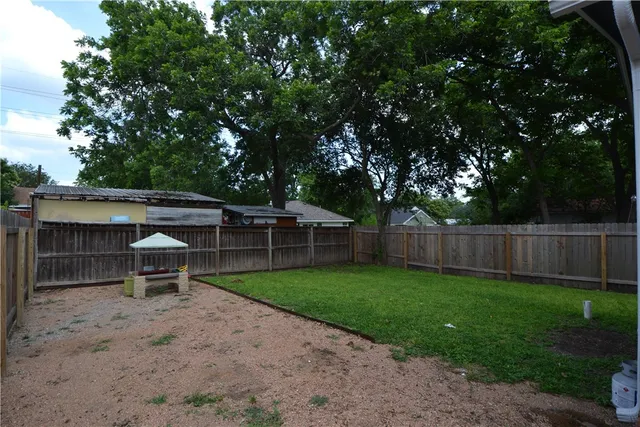 a backyard of a house with table and chairs