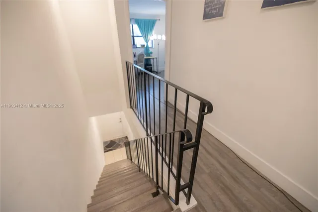 a view of a hallway with wooden floor and stairs