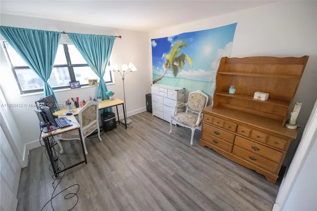 a view of room with wooden floor and furniture