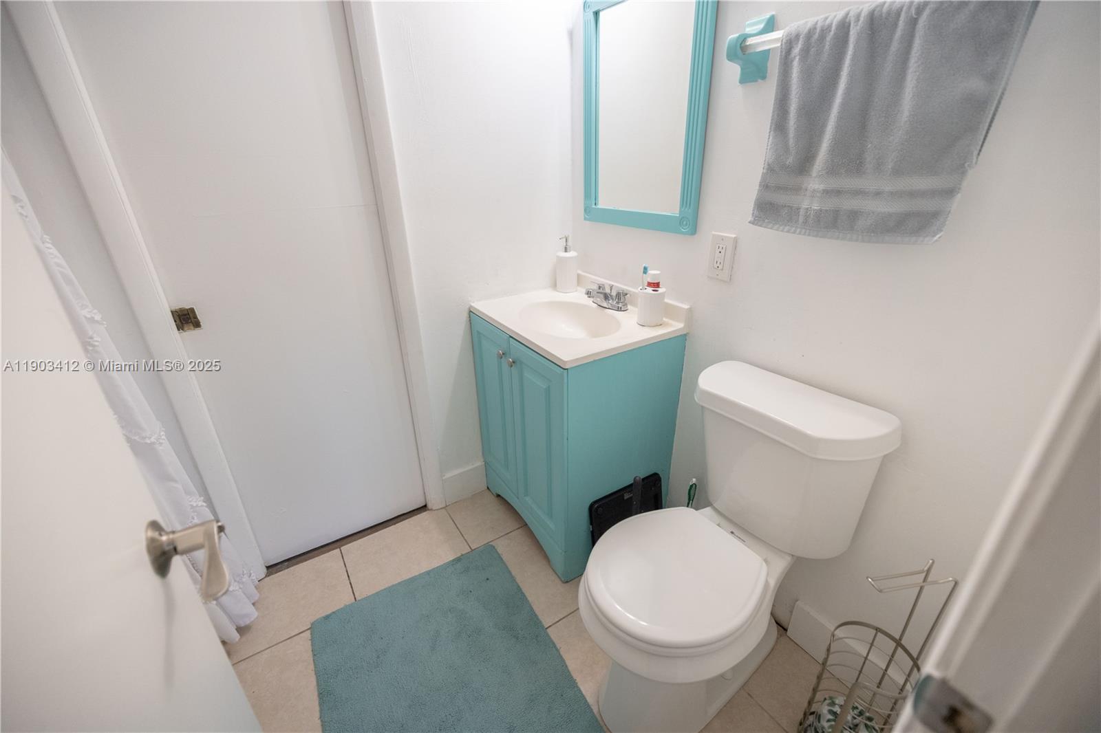 12955 Southwest 66th Lane, Unit 2092 Miami, FL 33183 - Photo 24 of 46 a white toilet sitting next to a bathroom sink and a mirror
