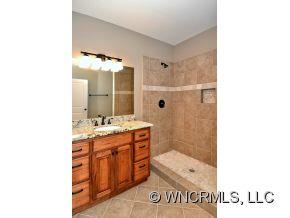 230 Porters Ridge Canton, NC 28716 - Photo 14 of 21 a bathroom with a granite countertop sink a mirror and a shower