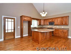230 Porters Ridge Canton, NC 28716 - Photo 6 of 21 a kitchen with kitchen island granite countertop a stove top oven a sink dishwasher a dining table and chairs with wooden floor