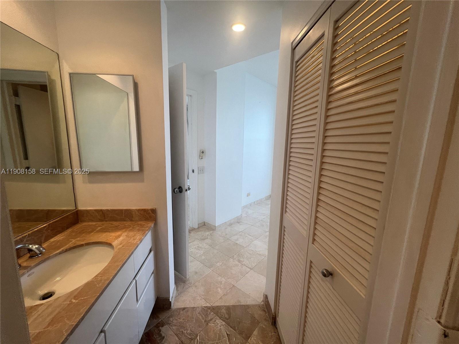 888 Brickell Key Drive, Unit 806 Miami, FL 33131 - Photo 13 of 20 a bathroom with a granite countertop sink and a mirror