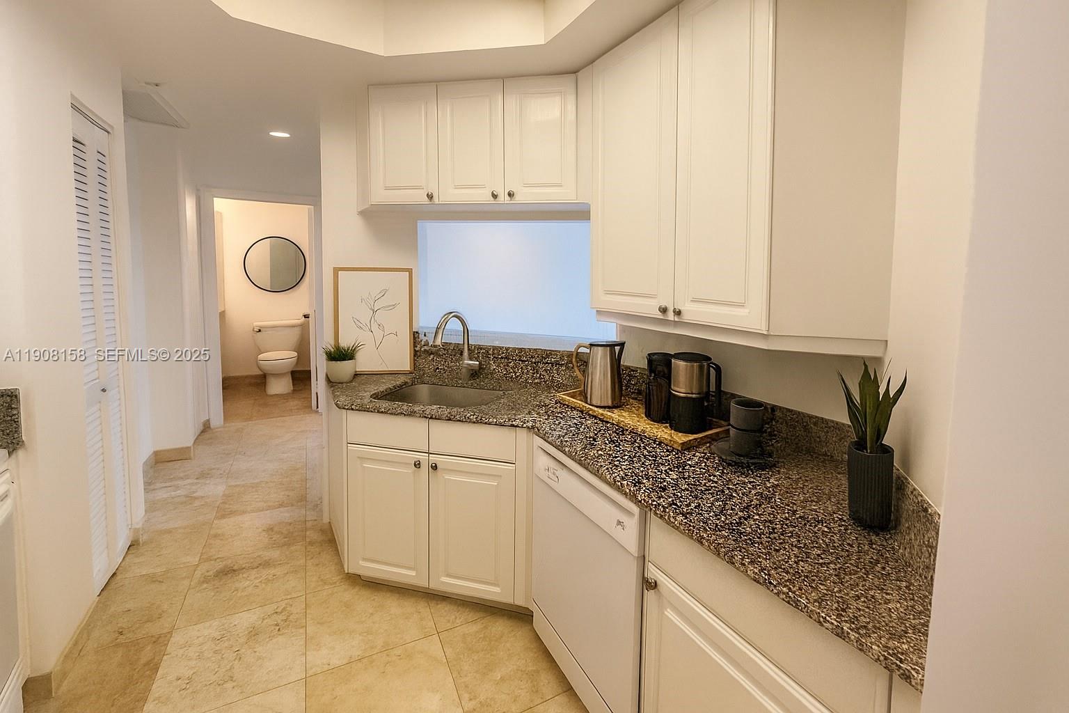 888 Brickell Key Drive, Unit 806 Miami, FL 33131 - Photo 5 of 20 a kitchen with stainless steel appliances granite countertop a sink and cabinets