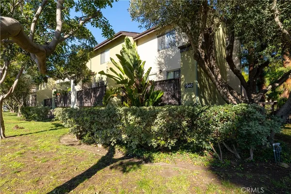 a view of a yard with plants and trees