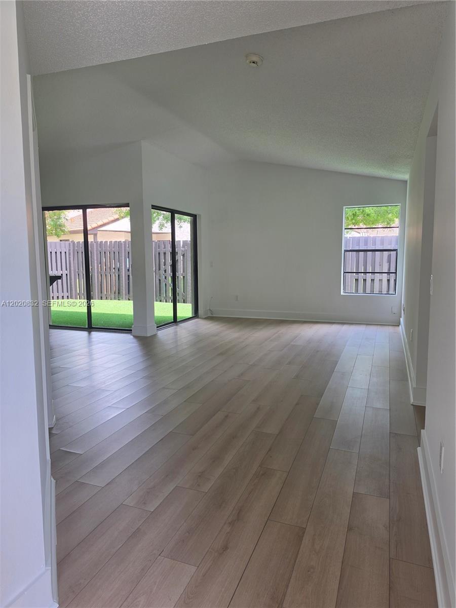 15240 Southwest 45th Terrace, Unit 54F Miami, FL 33185 - Photo 41 of 48 an empty room with wooden floor and a ceiling fan