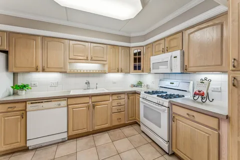 a kitchen with cabinets appliances a sink and a window