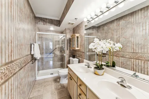 a bathroom with a sink a toilet and shower