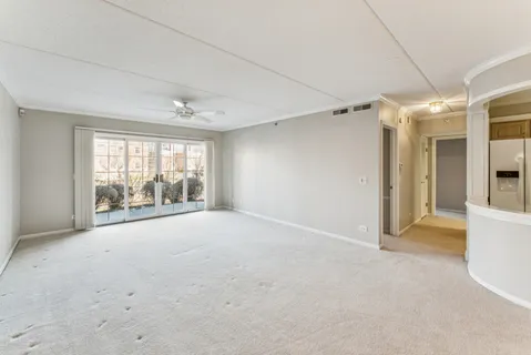 an empty room with floor to ceiling window and an outdoor view