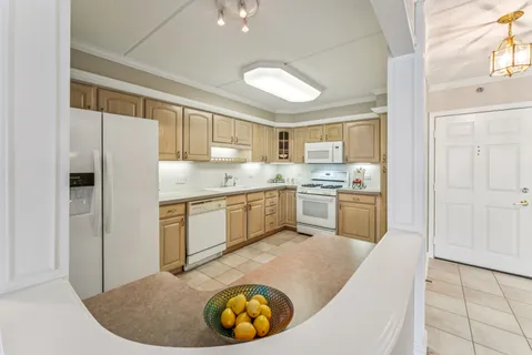 a kitchen with a sink a stove a refrigerator and white cabinets