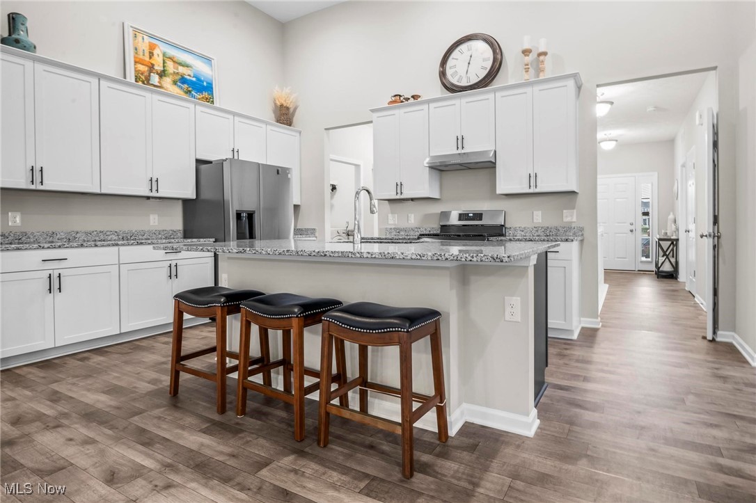 6824 Hatching Way North Ridgeville, OH 44039 - Photo 5 of 42 Kitchen with a kitchen island with sink, stove, stainless steel refrigerator with ice dispenser, and wood-type flooring