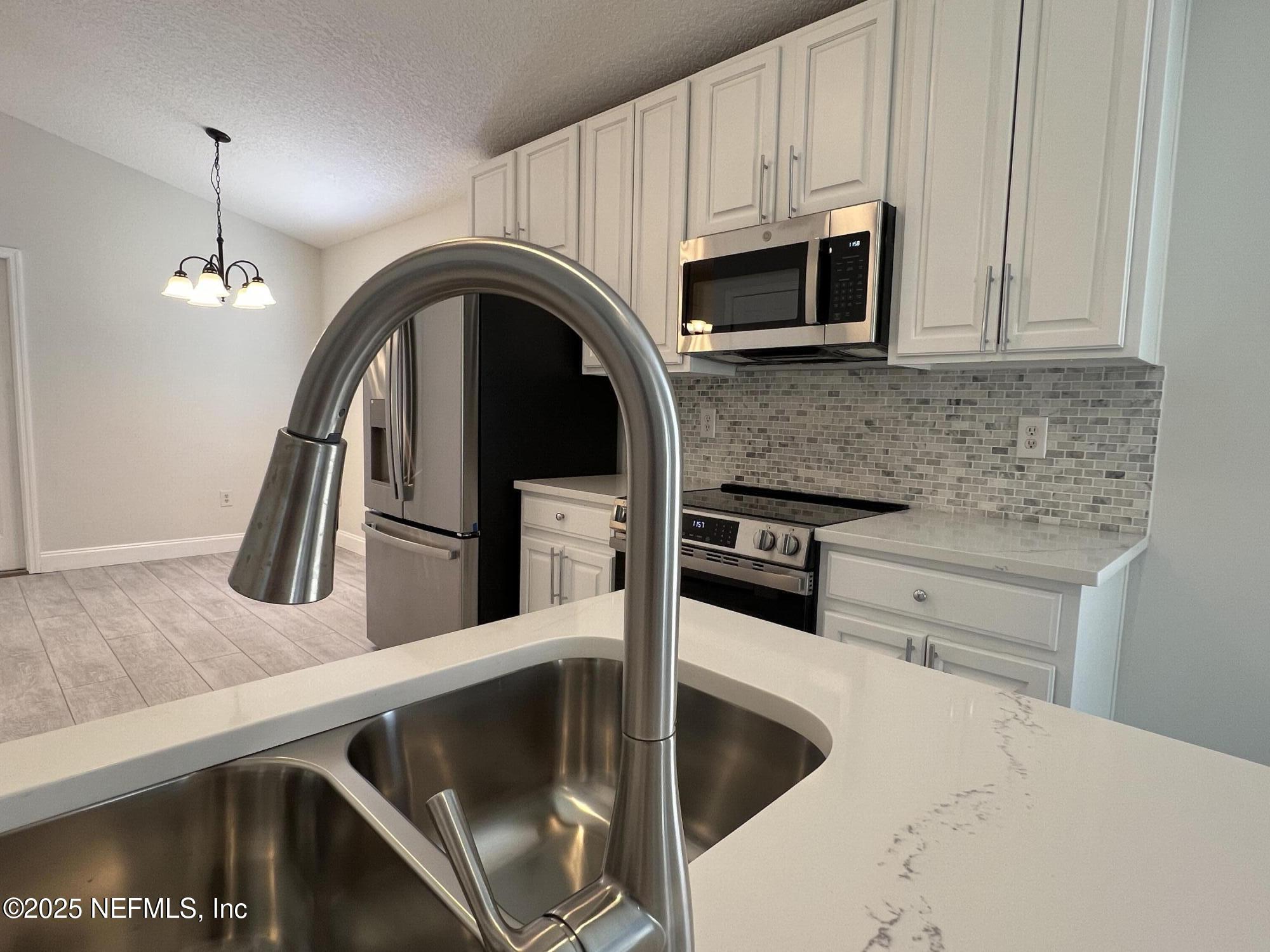 677 MacKenzie Circle St. Augustine, FL 32092 - Photo 15 of 92 a kitchen with stainless steel appliances granite countertop a sink and a microwave