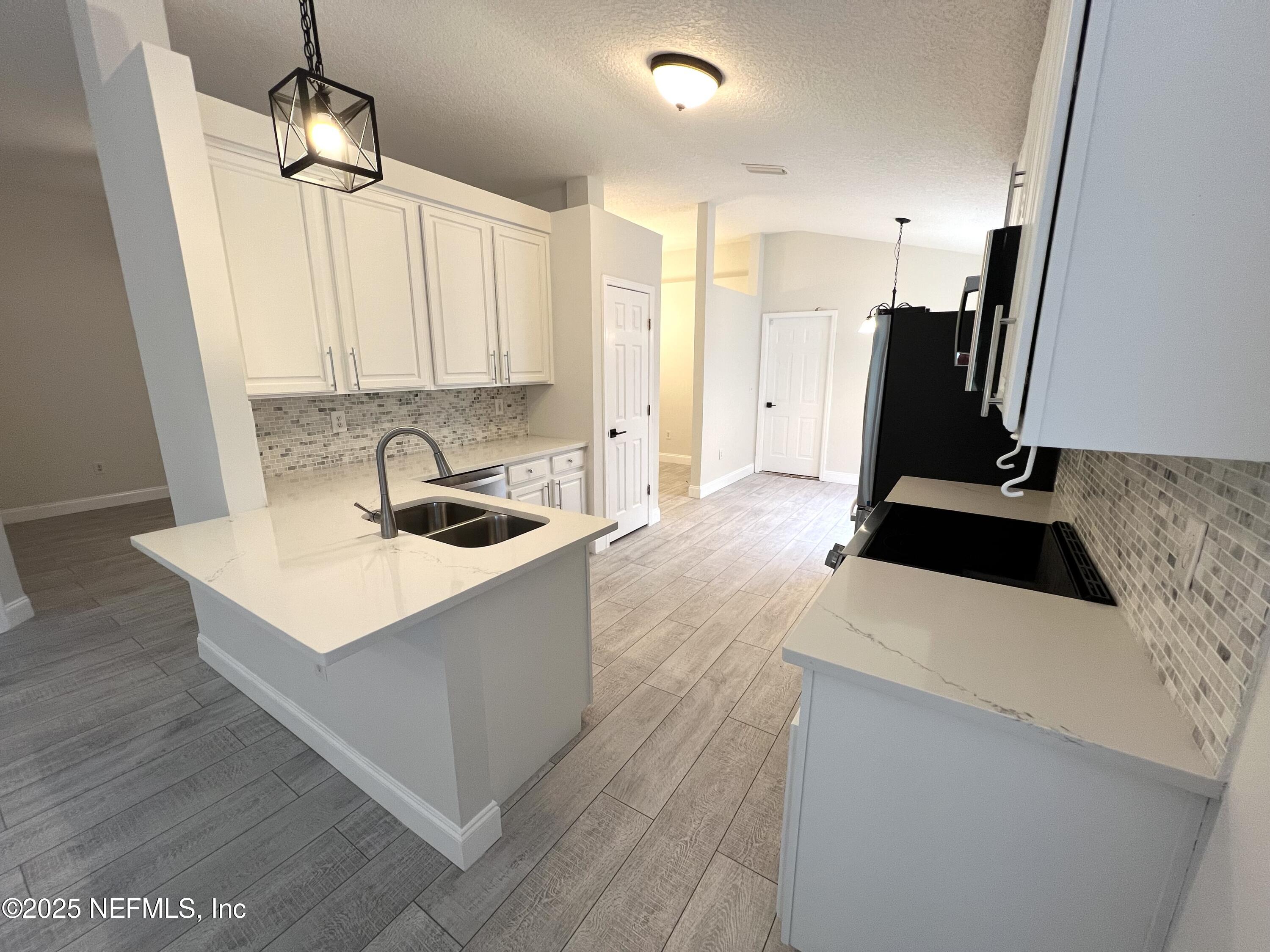 677 MacKenzie Circle St. Augustine, FL 32092 - Photo 4 of 92 a kitchen with a sink a stove a refrigerator and cabinets