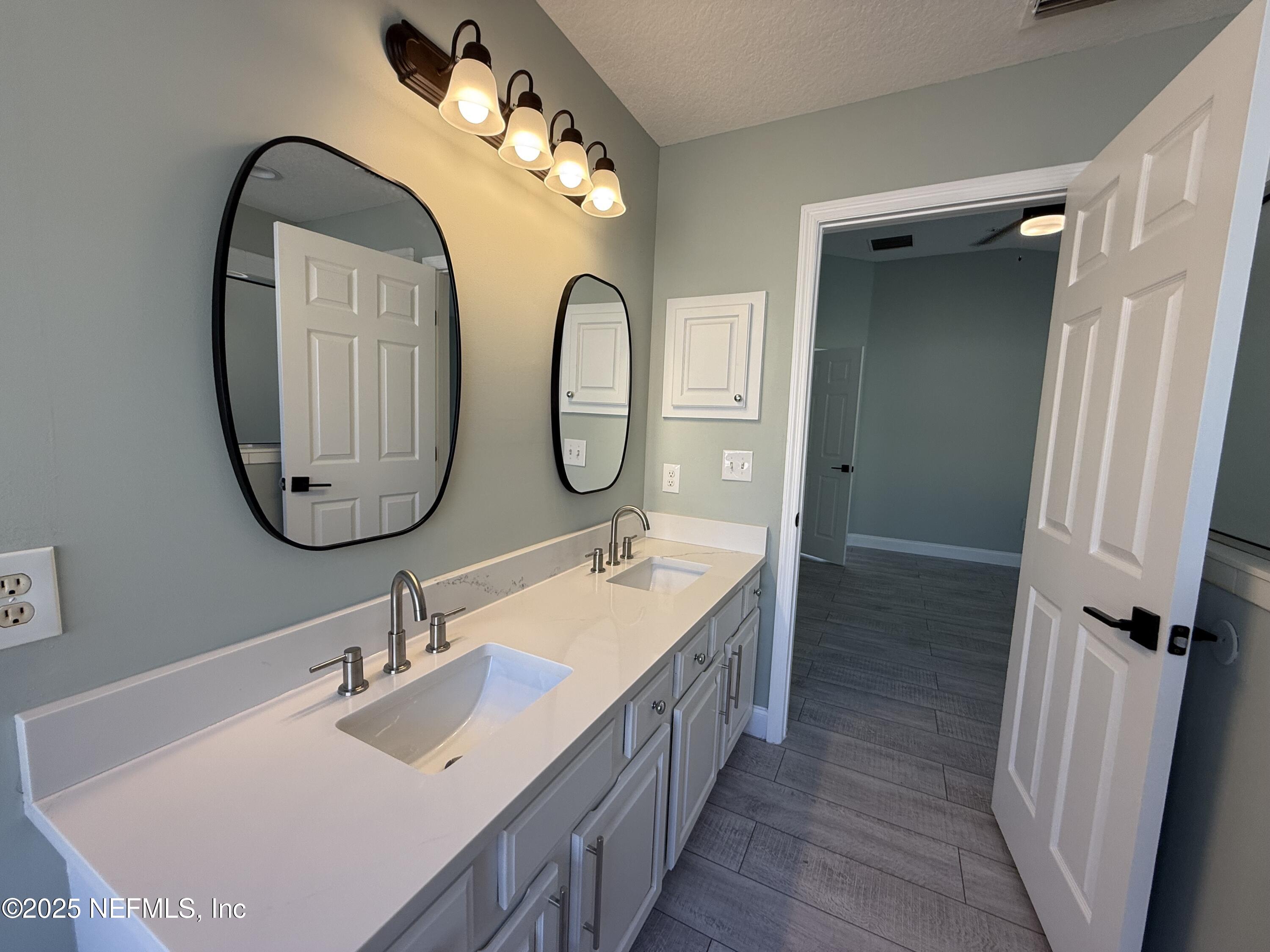 677 MacKenzie Circle St. Augustine, FL 32092 - Photo 46 of 92 a bathroom with a double vanity sink and a mirror