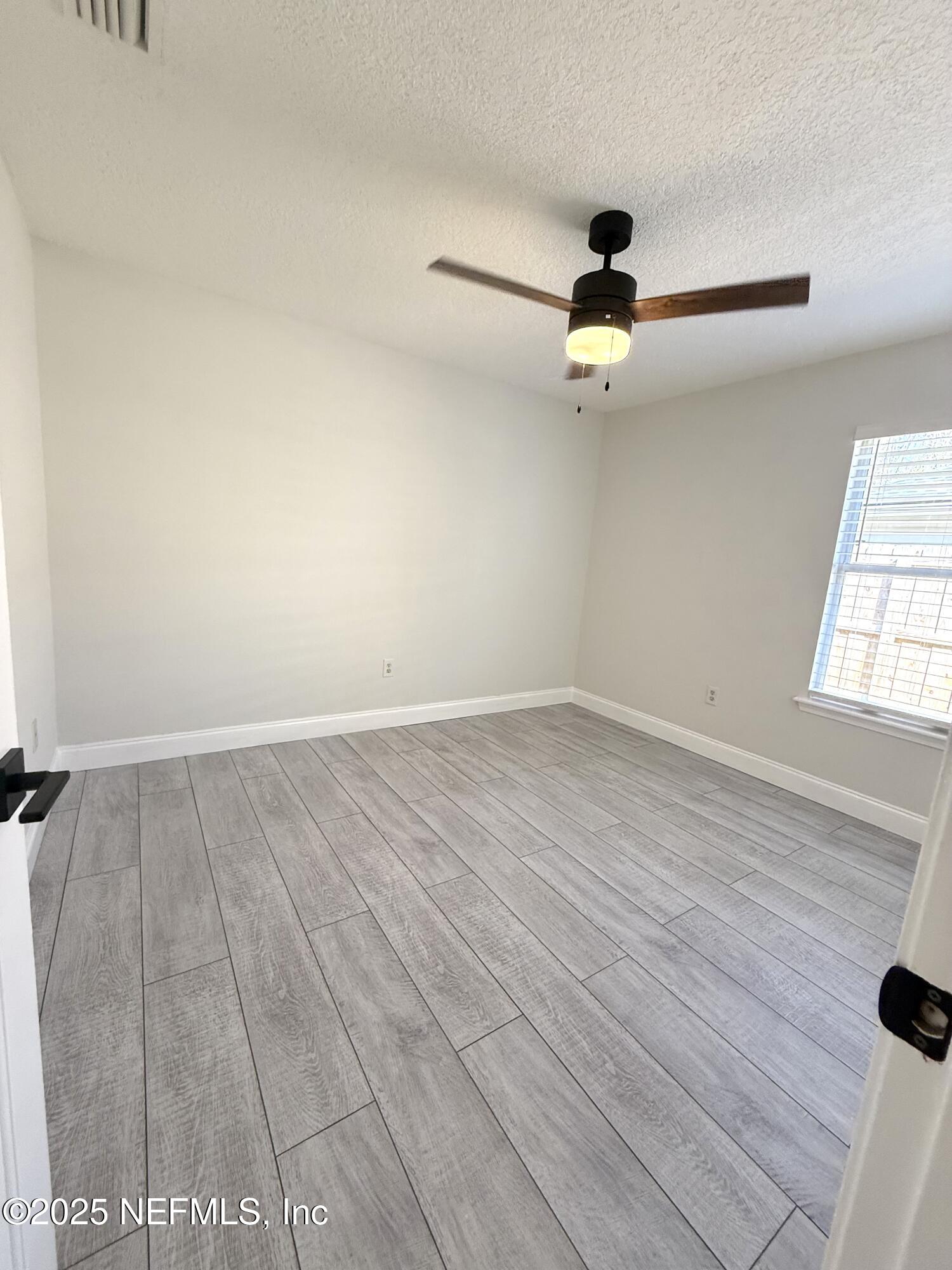 677 MacKenzie Circle St. Augustine, FL 32092 - Photo 50 of 92 an empty room with wooden floor cabinet and windows