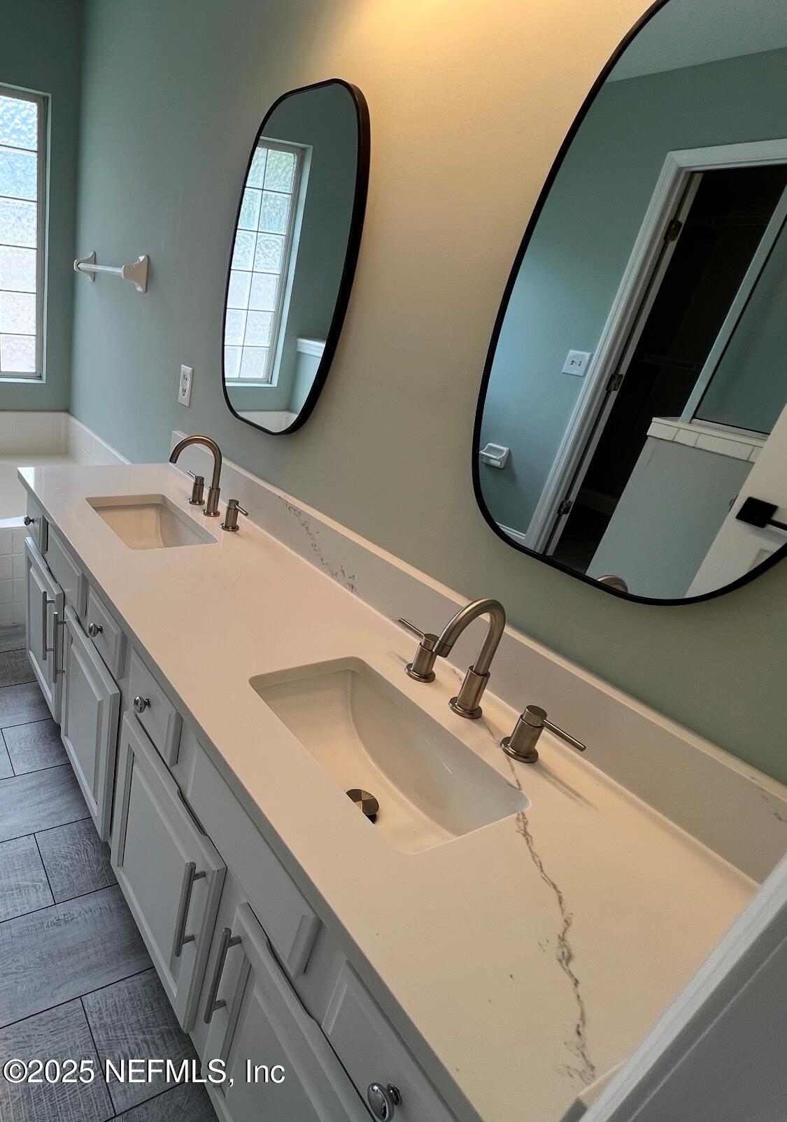 677 MacKenzie Circle St. Augustine, FL 32092 - Photo 64 of 92 a bathroom with a double vanity sink and a mirror