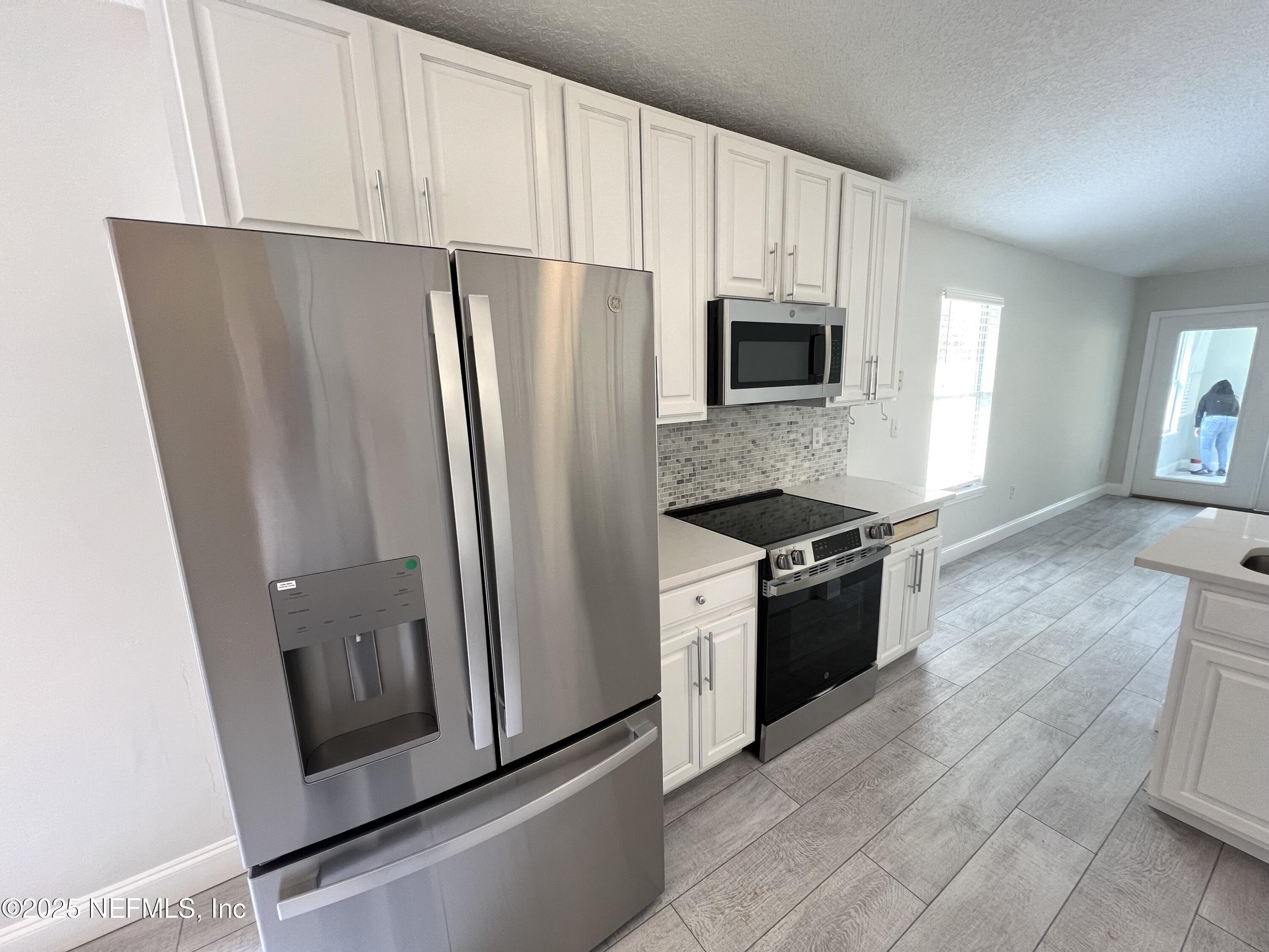 677 MacKenzie Circle St. Augustine, FL 32092 - Photo 72 of 92 a kitchen with granite countertop a refrigerator stove and microwave