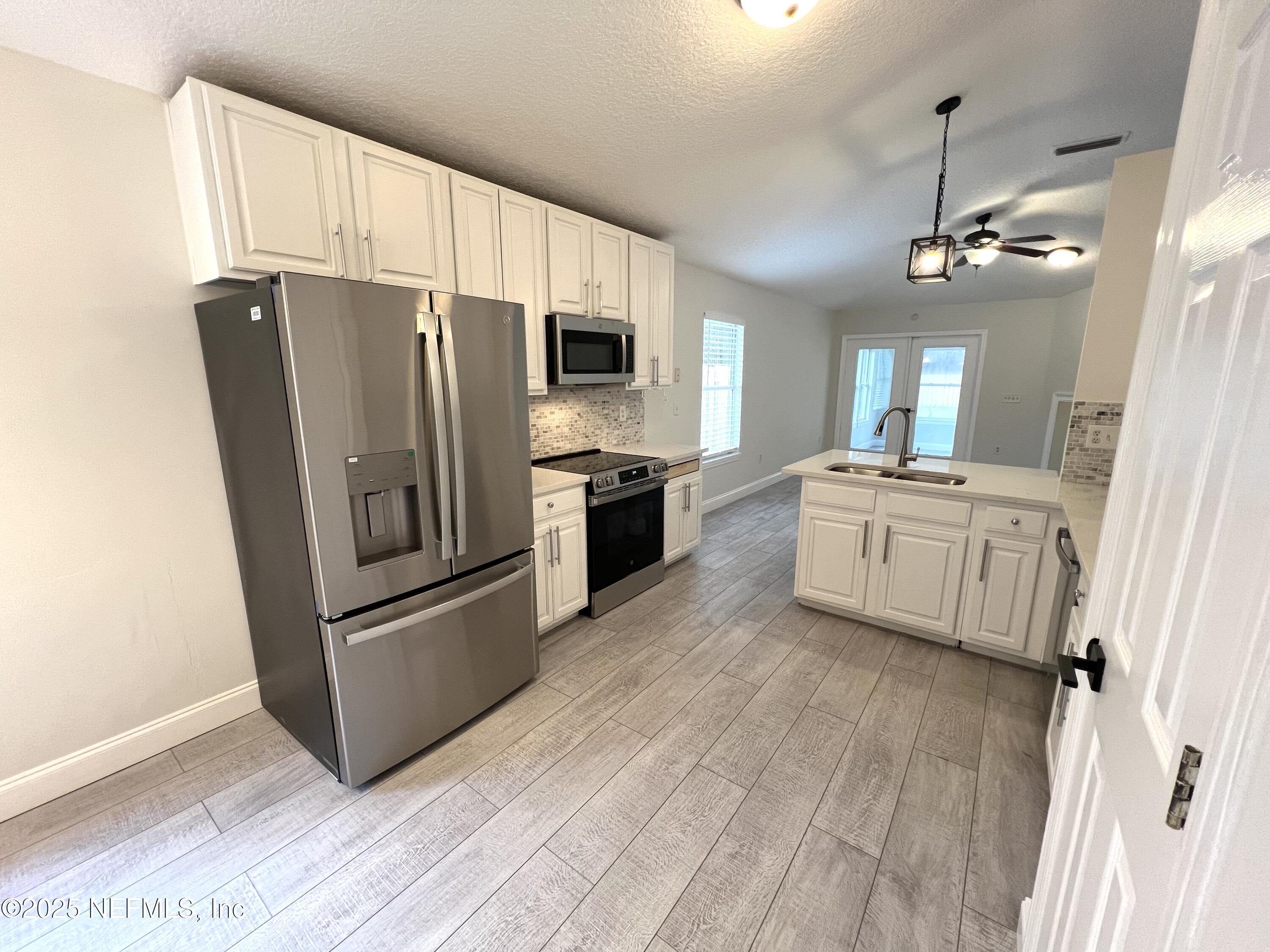 677 MacKenzie Circle St. Augustine, FL 32092 - Photo 87 of 92 a kitchen with stainless steel appliances a refrigerator sink and microwave