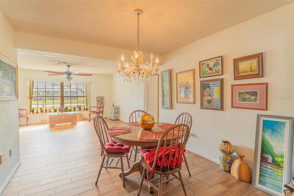 4202 Tangier Street Sebring, FL 33872 - Photo 14 of 29 a dining room with furniture a chandelier and wooden floor