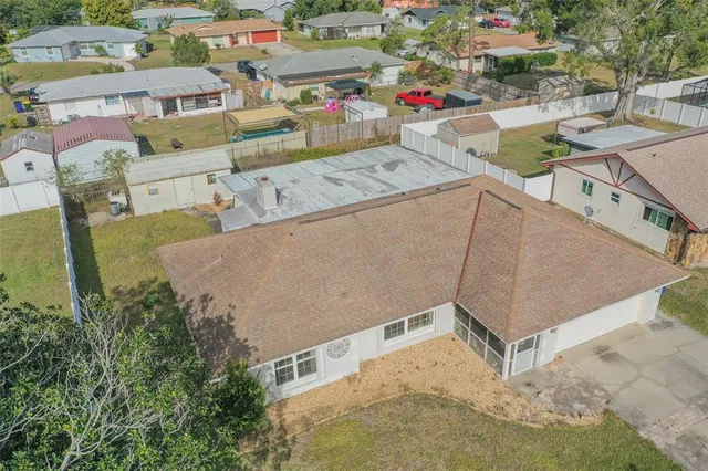 an aerial view of residential houses with outdoor space and trees
