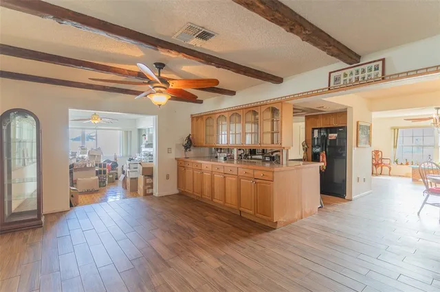 a view of a living room and kitchen with furniture wooden floor