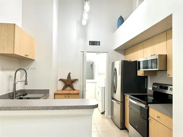 a kitchen with stainless steel appliances granite countertop a refrigerator and a stove top oven
