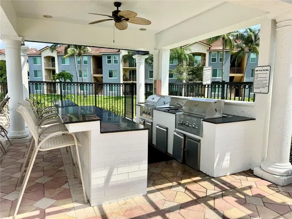 a kitchen with granite countertop a stove a sink and a dining table