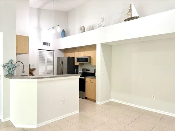 a kitchen with kitchen island a sink a stove and refrigerator