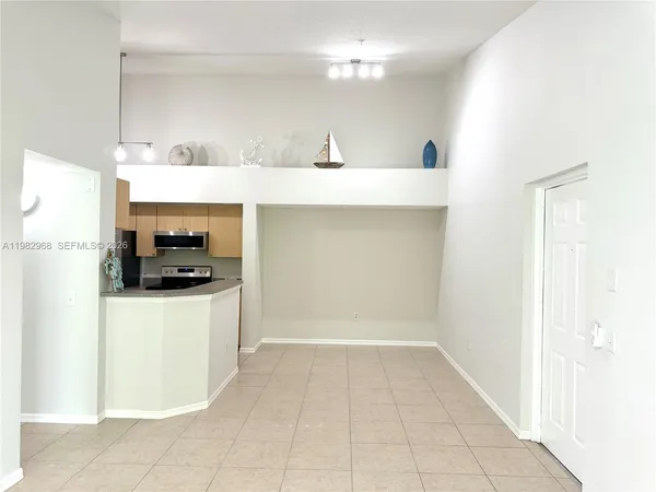 a kitchen with a sink a stove top oven and white cabinets