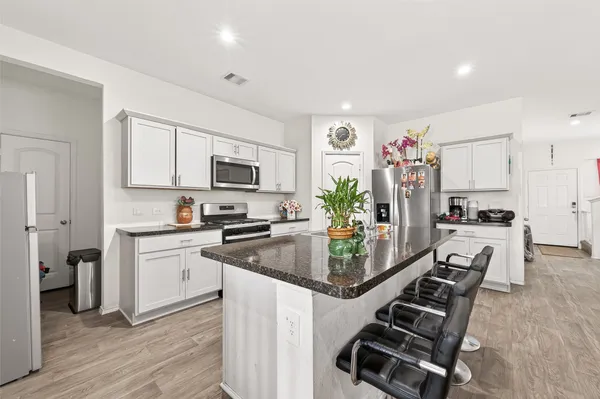 a kitchen with a sink refrigerator and cabinets