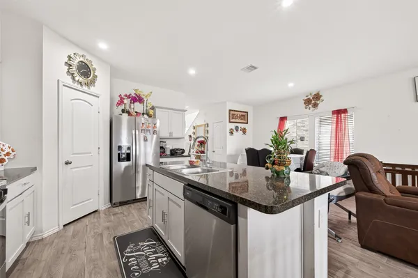 a kitchen with stainless steel appliances granite countertop a sink and a stove