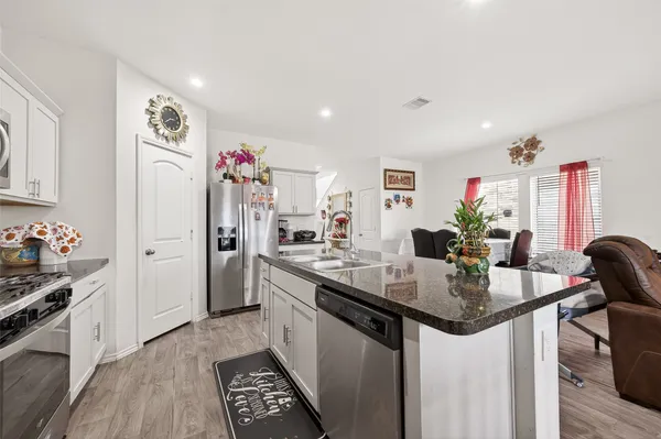 a kitchen with stainless steel appliances granite countertop a sink stove and refrigerator