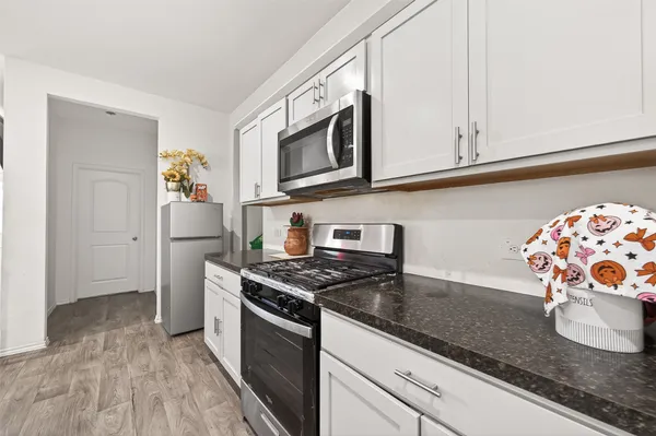 a kitchen with granite countertop a sink stainless steel appliances and cabinets
