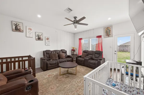 a living room with furniture a flat screen tv and a large window