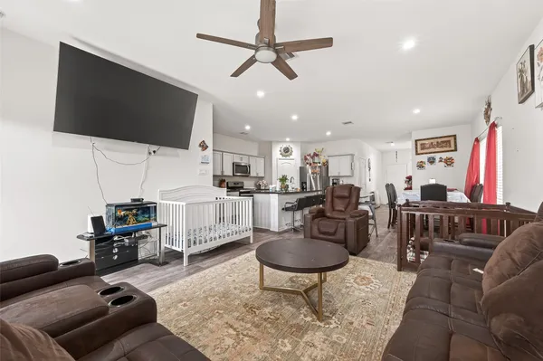 a kitchen with stainless steel appliances kitchen island granite countertop a table chairs sink and cabinets