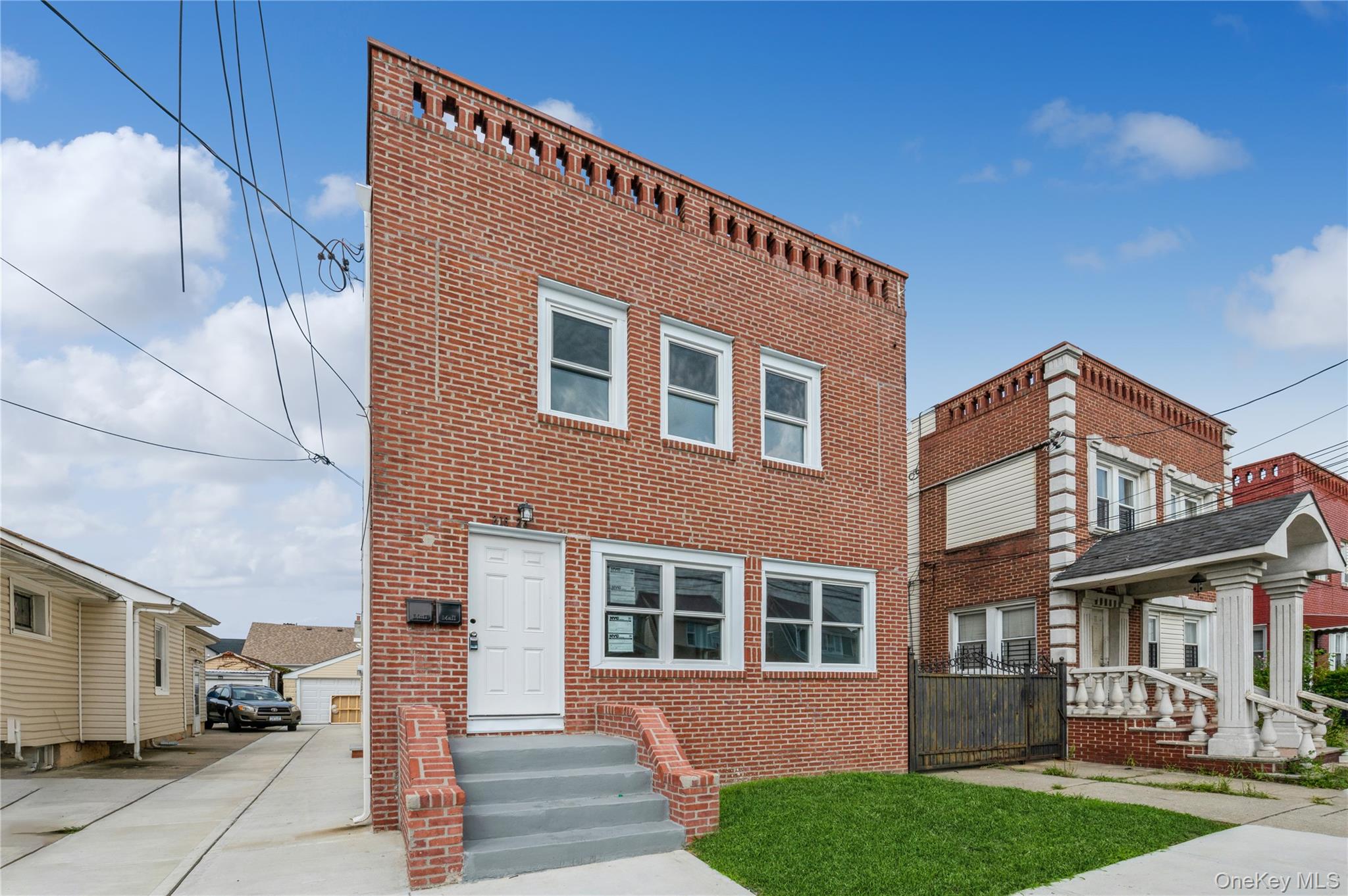 216-23 136th Road Queens, NY 11413 - Photo 1 of 1 View of front of property with brick siding and a front yard