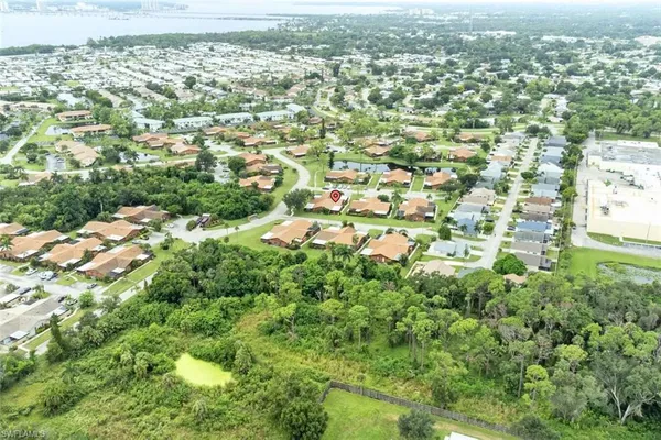 an aerial view of residential houses with outdoor space and trees