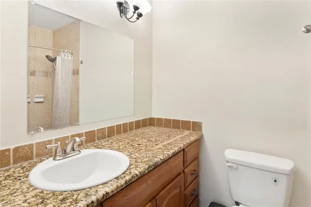 a bedroom with a large bed chandelier and a window