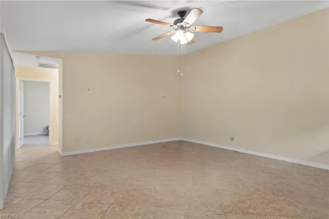 an empty room with a ceiling fan and carpet