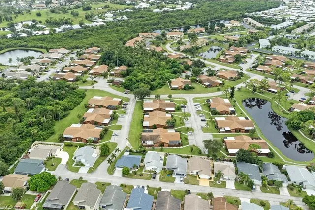 an aerial view of residential houses with outdoor space and trees