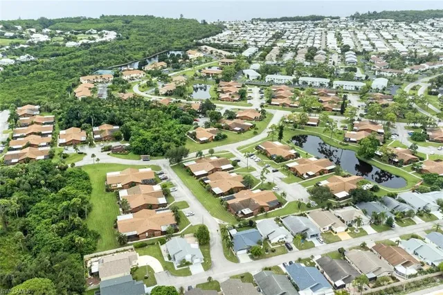 an aerial view of residential houses with outdoor space and parking