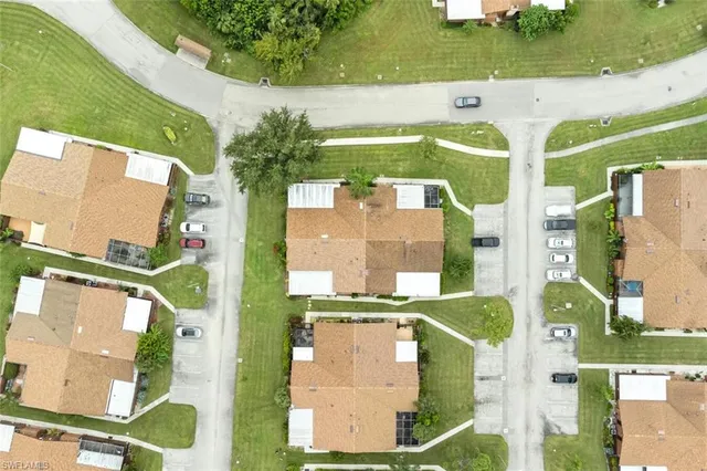 an aerial view of residential houses with outdoor space and swimming pool