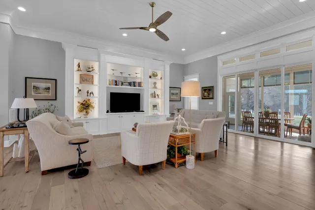 a living room with furniture kitchen view and a chandelier