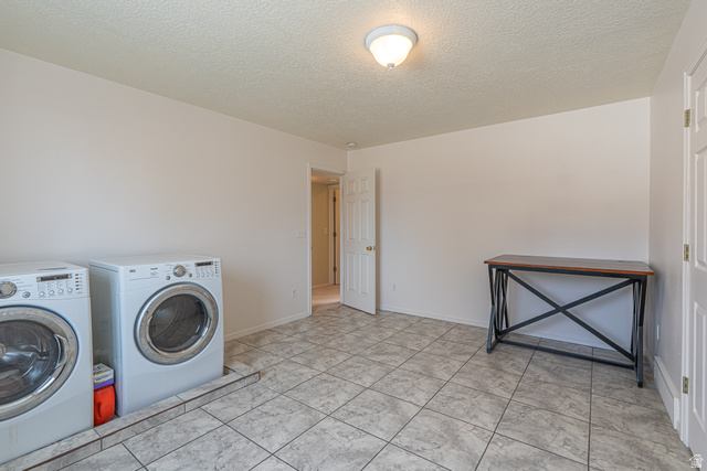 1045 Fox Farm Road Logan, UT 84321 - Photo 46 of 65 Laundry room featuring a textured ceiling and washer and clothes dryer