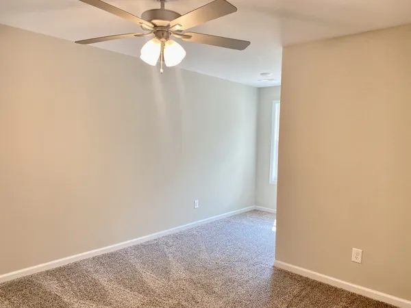 an empty room with a fan and a fan